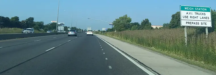 Southbound I-55 in Bolingbrook, Illinois, with a green sign: Weigh station, A.V.I. trucks use right lanes, PrePass site